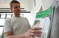 Ein Mitarbeiter des DPZ holt sich die neue Ausgabe von "DPZ aktuell" im Foyer. Foto: Christian Kiel
