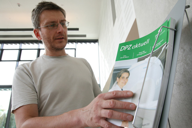 Ein Mitarbeiter des DPZ holt sich die neue Ausgabe von "DPZ aktuell" im Foyer. Foto: Christian Kiel