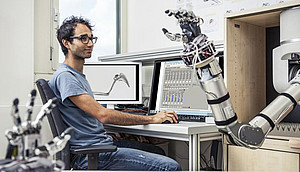 A Scientists programs a robotic arm to study motion sequences. Photo: Thomas Steuer
