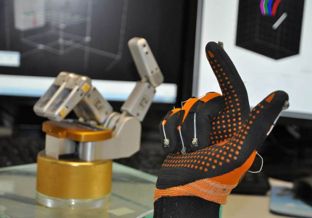 Datenhandschuh mit magnetischen Sensoren an den Fingerkuppen misst die Fingerbewegungen einer Versuchsperson, welche auf eine Roboterhand übertragen werden. Foto: Stefan Schaffelhofer