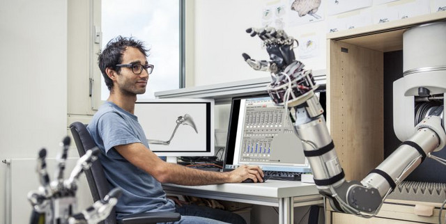 Post-Doktorand Andres Agudelo-Toro programmiert eine Roboterhand um Bewegungsabläufe zu studieren. Foto: Thomas Steuer