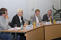 Das Foto zeigt vier Männer an einem Tisch.